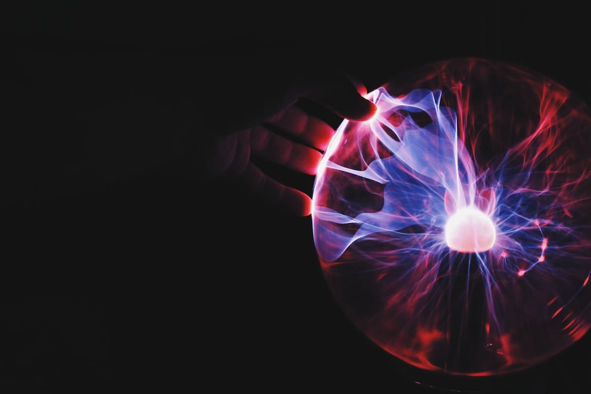 Hand touching a glowing plasma sphere representing automated campaigns